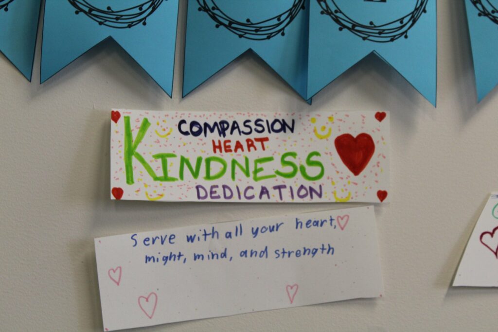 Picture of a sign that reads compassion heart kindness dedication