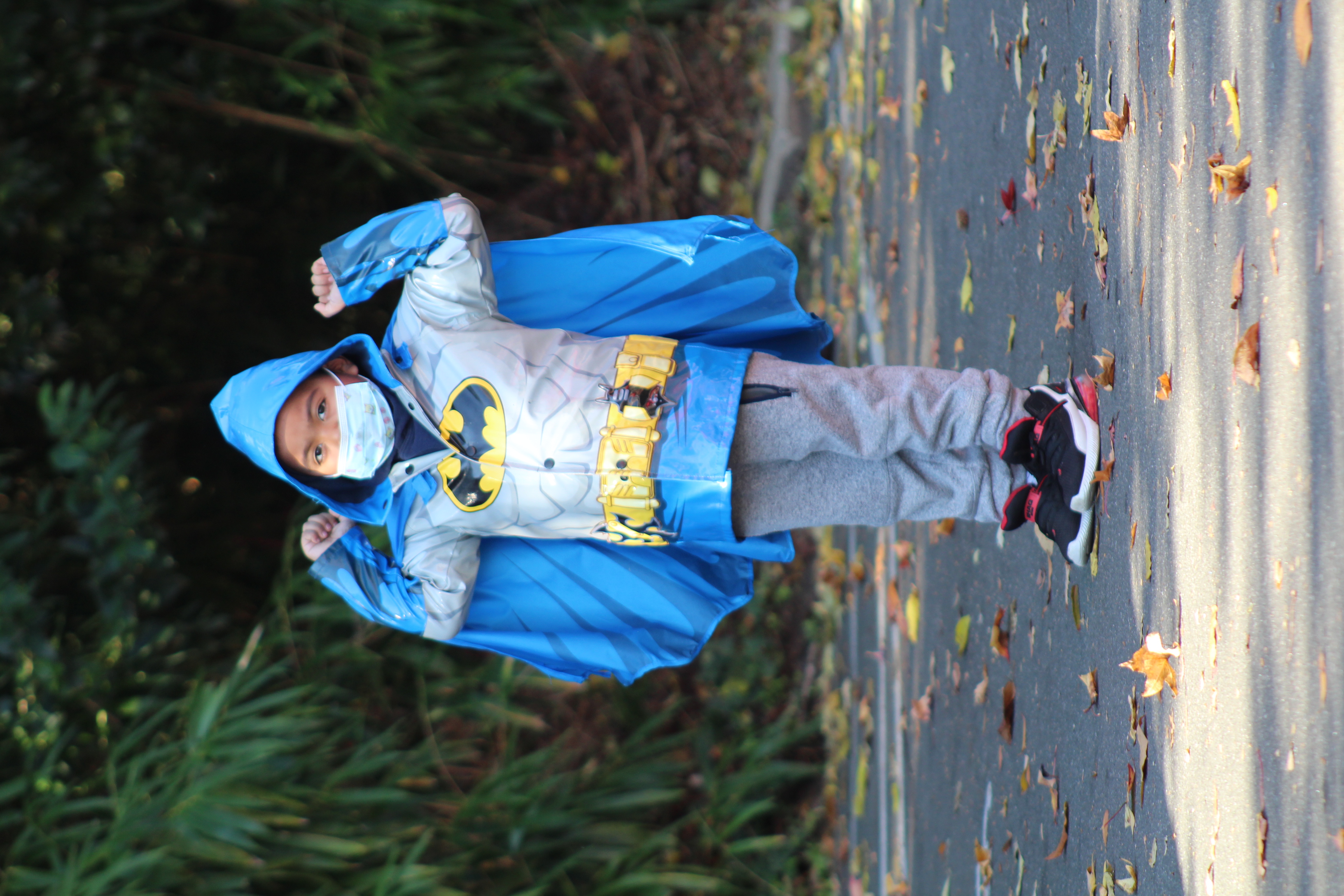Young boy in a blue Batman raincoat