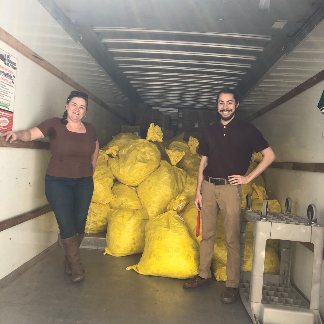 Family & Consumer Science Agent, Cheralyn Berry and Gaebryl Vives standing in box truck after loading 10,000 lbs. of seeds