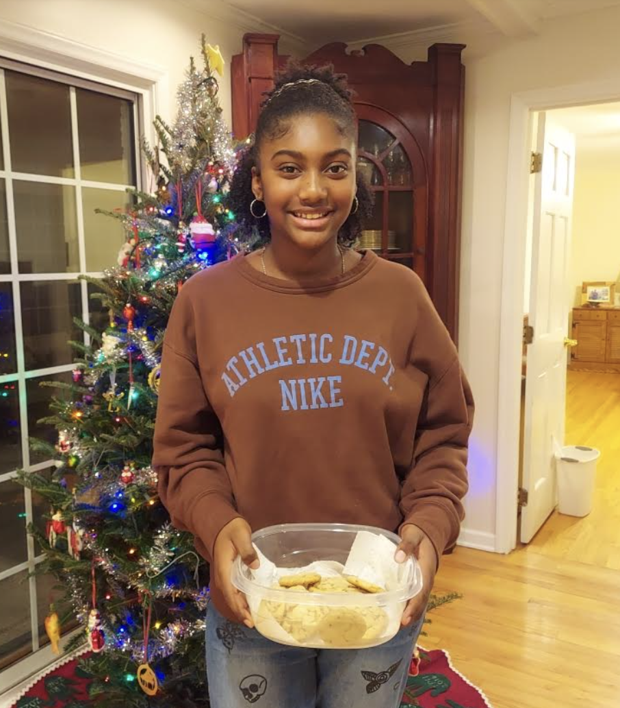 A girl poses with a batch of cookies.